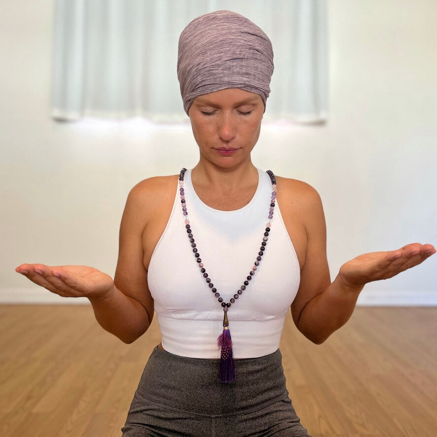 Women wearing turban with amethyst crystal necklace with purple tassel