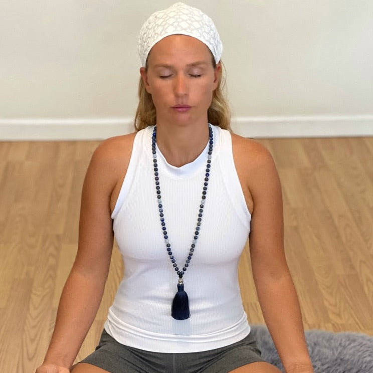 women in meditation wearing third eye necklace made from lapis lazuli gemstones