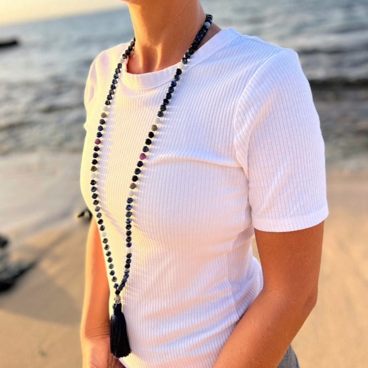 women at ocean wearing third eye necklace made from lapis lazuli crystal