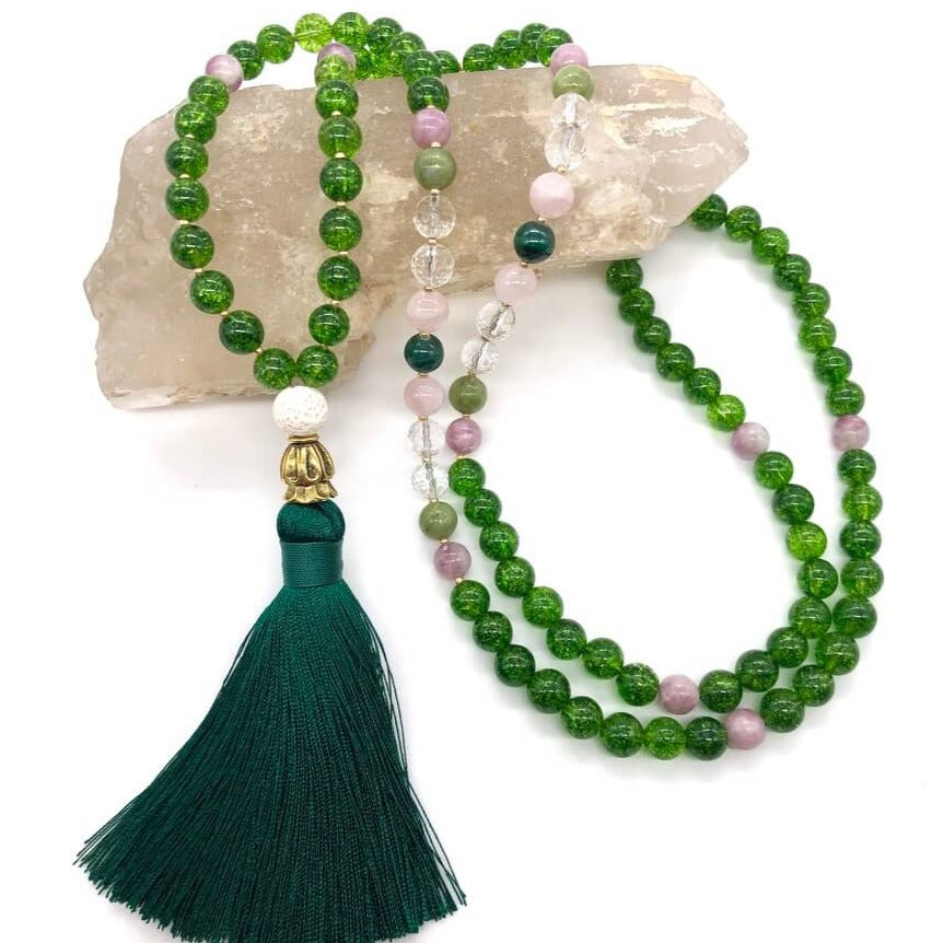 green crystal necklace made from peridot stones sits on top of smokey quartz