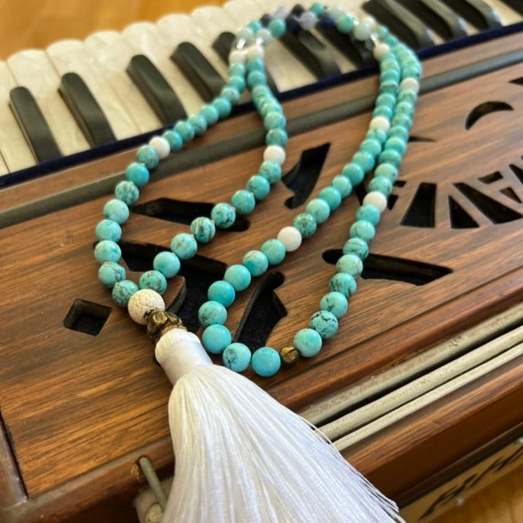 turquoise stone necklace sitting on top of harmonium 