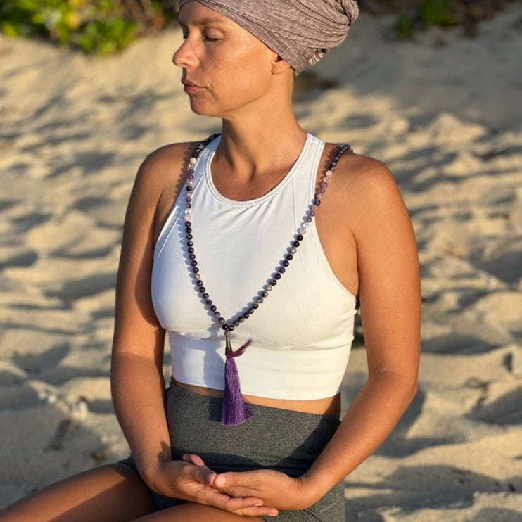 women at beach wearing amethyst crystal necklace 