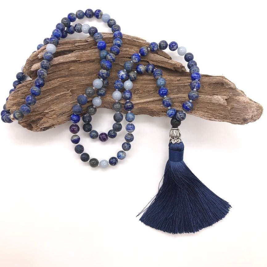 third eye necklace made from lapis lazuli gemstones sits on top of wood